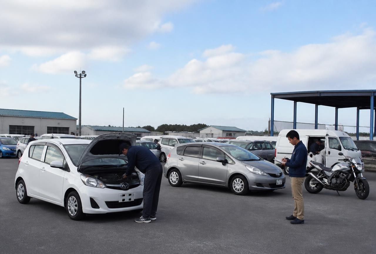 Compact cars, a van and a motorcycle in a vehicle inspection yard